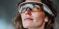 Female scientist wearing protective safety goggles in laboratory environment for research and development work in STEM field.