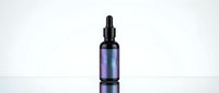 Purple iridescent dropper bottle with black cap on white background, cosmetic serum container for skincare beauty products and essential oils packaging.