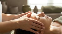 Relaxing facial massage therapy session with professional hands gently massaging woman's face in serene spa environment for wellness and skincare treatment.