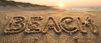 Word BEACH written in golden sand with seashells at sunset, warm ocean shore background for summer travel and vacation concepts.
