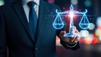 Professional businessman in dark suit holding glowing digital scales of justice hologram representing legal technology and law firm innovation.