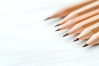 Sharp wooden pencils arranged diagonally on white background with soft focus and copy space, minimalist composition for education and creativity concepts.