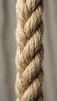 Natural jute rope with detailed braided texture showing organic hemp fibers in rustic brown tones for nautical and craft projects.