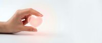 Caucasian hand making small gesture with fingers pinched together against soft pink light background, conveying tiny size or minimal concept.