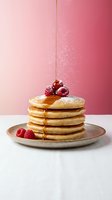 Stack of fluffy pancakes with maple syrup, fresh raspberries and powdered sugar dusting on ceramic plate against pink gradient background for breakfast menu.