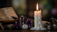 Mystical altar setup with burning candle, crystals, ancient book and ornate objects for spiritual rituals, meditation and esoteric practices.