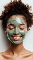 Young African American woman with natural curly hair wearing green clay facial mask, smiling with closed eyes against white background. For beauty and skincare advertising.