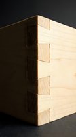 Close-up of precision dovetail joint woodworking showcasing traditional carpentry craftsmanship and joinery techniques for furniture making projects.
