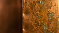 Aged copper surface with natural patina and oxidation showing rich orange and green verdigris textures for industrial design projects.