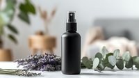 Black cosmetic spray bottle with lavender and eucalyptus on white surface, showcasing natural skincare ingredients for beauty product photography.