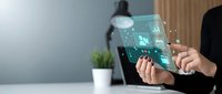 Businesswoman holding transparent tablet with digital holographic interface displaying data analytics and network icons for corporate technology solutions.