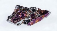 Raw purple amethyst crystal cluster with metallic inclusions on white background, natural gemstone specimen for jewelry making and mineral collection displays.