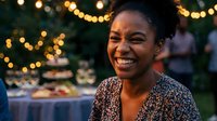 Happy African American woman smiling at outdoor evening event with warm string lights creating festive atmosphere for celebrations and gatherings.