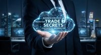 Businessman holding glowing cloud with trade secrets text in modern office at night. Corporate data protection and confidential business information concept.