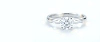 Elegant diamond solitaire engagement ring with brilliant cut stone on white gold band isolated on white background for jewelry design.