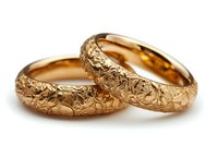 Pair of textured gold wedding bands with hammered surface finish, isolated on white background, suitable for jewelry marketing, wedding catalogs, and e-commerce design.