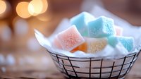 Colorful sugar-coated jelly candies in metal wire basket with warm bokeh lights background for sweet treats and confectionery marketing materials.