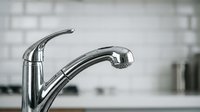 Modern chrome kitchen faucet with sleek curved design in contemporary home interior for plumbing and renovation projects.