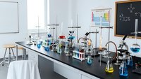 Modern chemistry laboratory with scientific equipment, glassware, beakers and test tubes on black countertop for educational research and experiments.