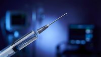 Medical syringe with needle on blurred hospital background. Healthcare injection equipment for vaccination, treatment and medical procedures.