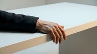 Hand resting on wooden rail wearing black sleeve, minimalist composition for business, corporate, or lifestyle design projects.