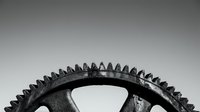 Industrial metal gear wheel with sharp teeth on neutral background for mechanical engineering and manufacturing concepts.