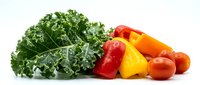 Fresh kale leaves with colorful bell peppers and cherry tomatoes isolated on white background for healthy cooking and meal preparation.