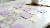 Colorful sticky notes arranged on marble desk surface for brainstorming and planning sessions with coffee cup and pen in background workspace.