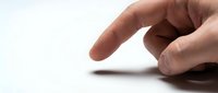Human hand with index finger pointing downward in gesture motion against clean white background for business and communication concepts.