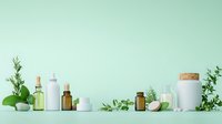 Natural cosmetic containers with green leaves and citrus fruits arranged on mint background, eco-friendly skincare products for beauty and wellness.