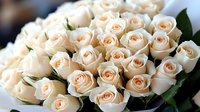 Elegant bouquet of cream and peach roses arranged in luxurious floral display for wedding, romance, anniversary celebration or special occasion gift.
