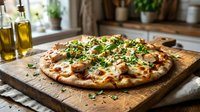 Freshly baked pizza topped with melted cheese, herbs and garnishes served on wooden board in bright kitchen setting for food photography and culinary content.