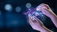 Hands holding glowing purple digital energy waves and particles against dark blue bokeh background, representing technology, innovation, and digital connection for web and design projects.