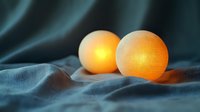 Glowing cotton ball string lights creating warm ambiance on soft blue fabric, perfect for cozy home decor.