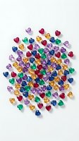 Colorful heart-shaped gemstones scattered on white background for jewelry making, crafts and romantic decorations.