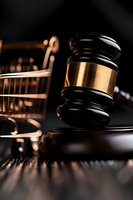 Wooden judge gavel with brass detail on dark background, dramatic lighting creates legal atmosphere. Conceptual composition for law and justice system.