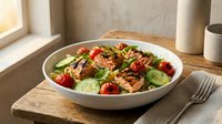 Fresh grilled salmon salad with mixed greens, cherry tomatoes and cucumber in white bowl on wooden table for healthy dining and restaurant menu.