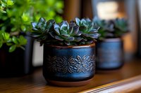 Succulent plant in decorative blue ceramic pot with floral pattern, shallow depth of field creates soft background blur. Natural home decor on wooden surface.