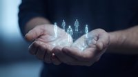 Businessman hands holding glowing holographic human figures representing team management, leadership and human resources in corporate environment.