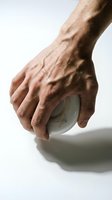 Male hand gripping transparent glass sphere on white background showing strength and control concepts for business presentations and metaphorical designs.