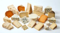 Assorted cheese varieties including cheddar, brie, blue cheese, and aged blocks isolated on white background for food photography, culinary design, restaurant menus, and dairy product marketing.