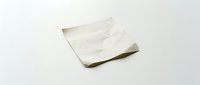 Crumpled white paper napkin or tissue isolated on light background, suitable for food service, hygiene, and cleaning product designs.