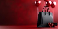 Black shopping bag with heart decorations on red background with bokeh lights, romantic Valentine's day sale concept for retail and commerce.