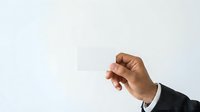 Businessman hand holding blank white card isolated on light background for business messaging and corporate branding.