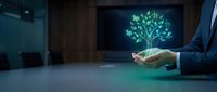 Businessman holding glowing green tree hologram symbolizing growth, sustainability and environmental responsibility in modern office setting.