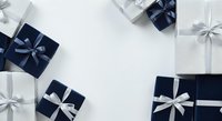 Overhead view of navy and white wrapped gift boxes with ribbon bows arranged on white background, ideal for holiday, celebration, and seasonal marketing materials.