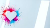 White heart symbol with vibrant pink and blue paint splashes on clean background for romantic designs and creative projects.