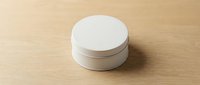 Round white blank metal tin container on wooden surface, mockup template for branding, packaging design, cosmetics or food product presentation.