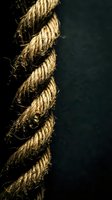 Twisted natural rope with frayed fibers against dark background showcasing rustic texture and organic material for nautical and industrial design projects.