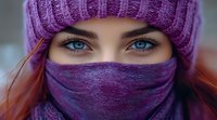 Young woman with striking blue eyes wearing purple winter knit beanie and matching face covering scarf, close up portrait showing intense gaze and expressive look.